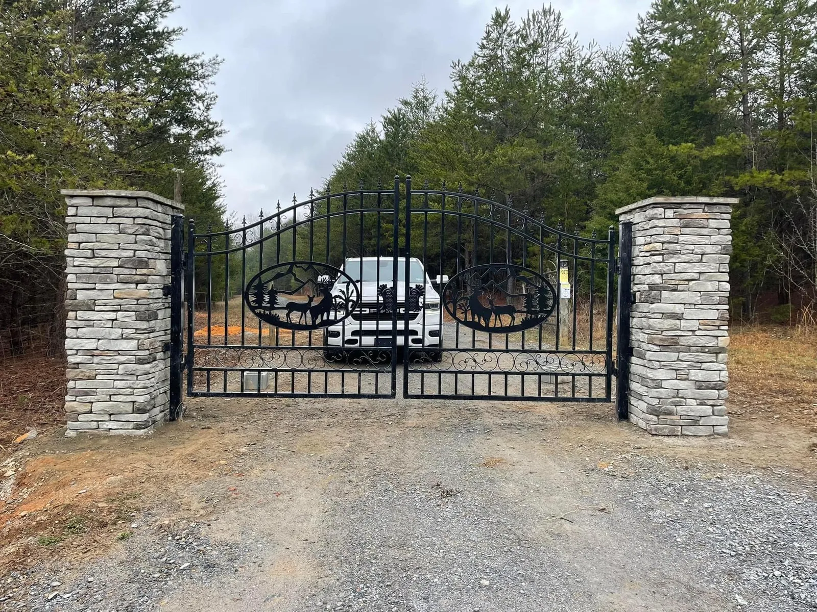 Stone column gate and graded gravel driveway entrance